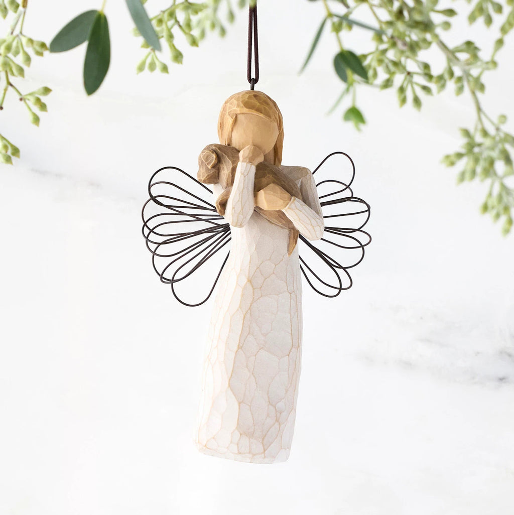 Female angel figure in cream dress with wire wings, holding brown dog in arms, ornament loop attached to head