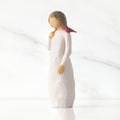 Front view of standing figure in cream dress with cardinal red bird perched on shoulder