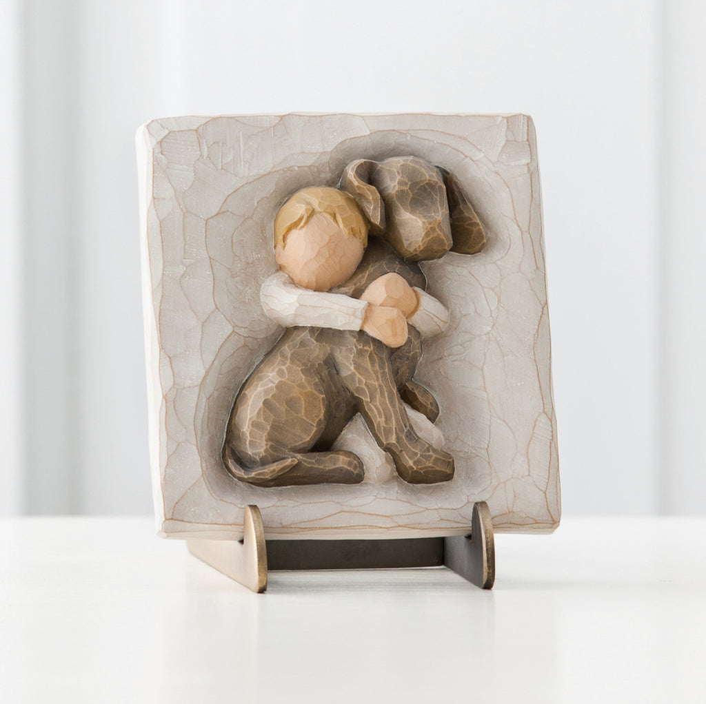 Cream square plaque stand with boy hugging brown puppy carved in