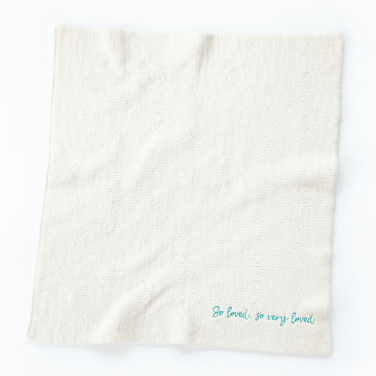 Overview of white towel with 'so loved, so very loved' in light blue in the right corner