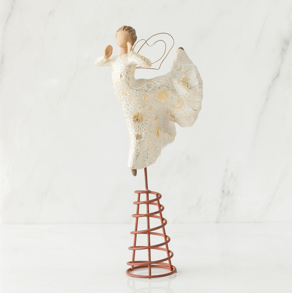 Angel figurine standing on red stand wearing white dress