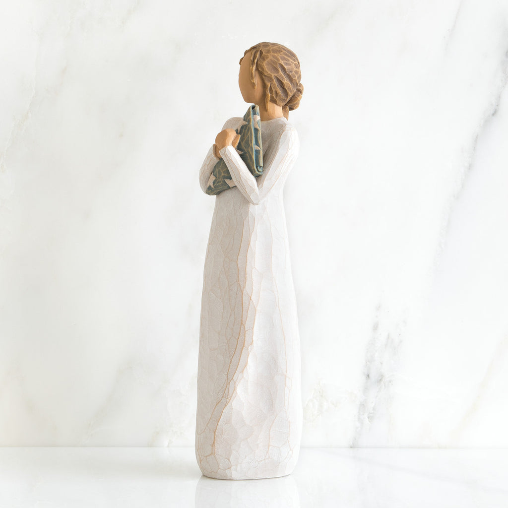 Side view of brunette girl figurine in white dress holding triangle figurine