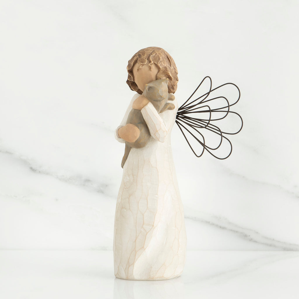 Small brunette angel figurine in white dress holding golden cat