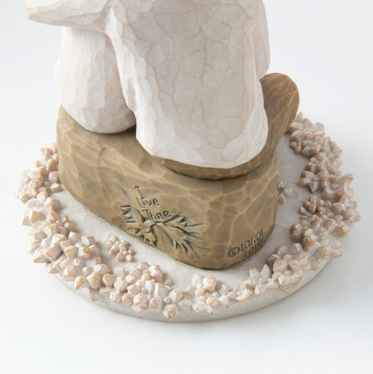 Close view of round white plaque with golden rock on top