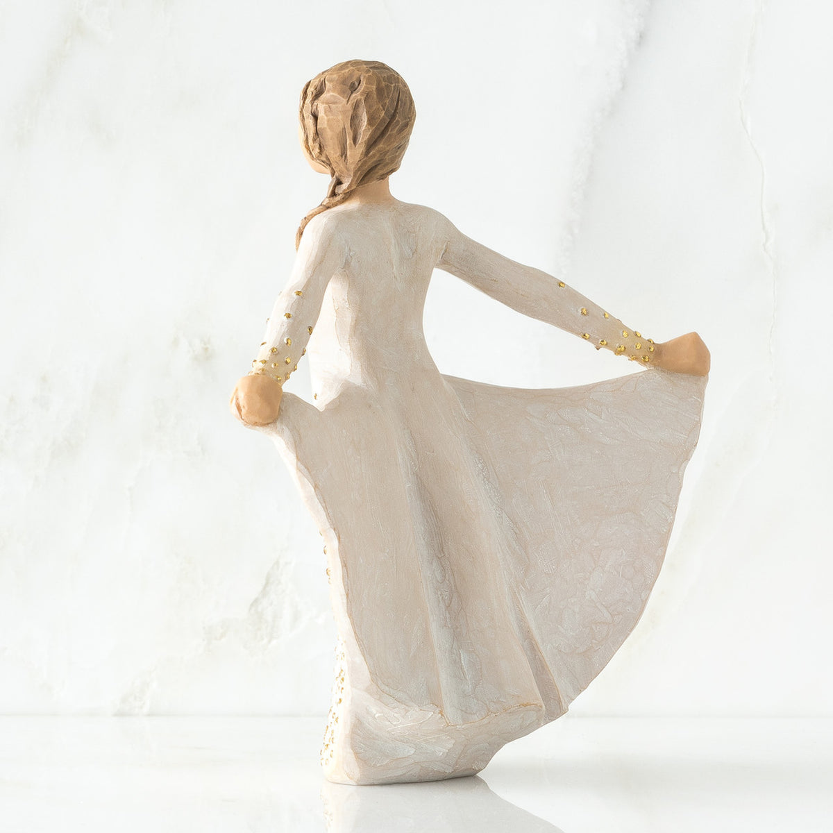 Back view of brunette woman in white dress holding up her dress