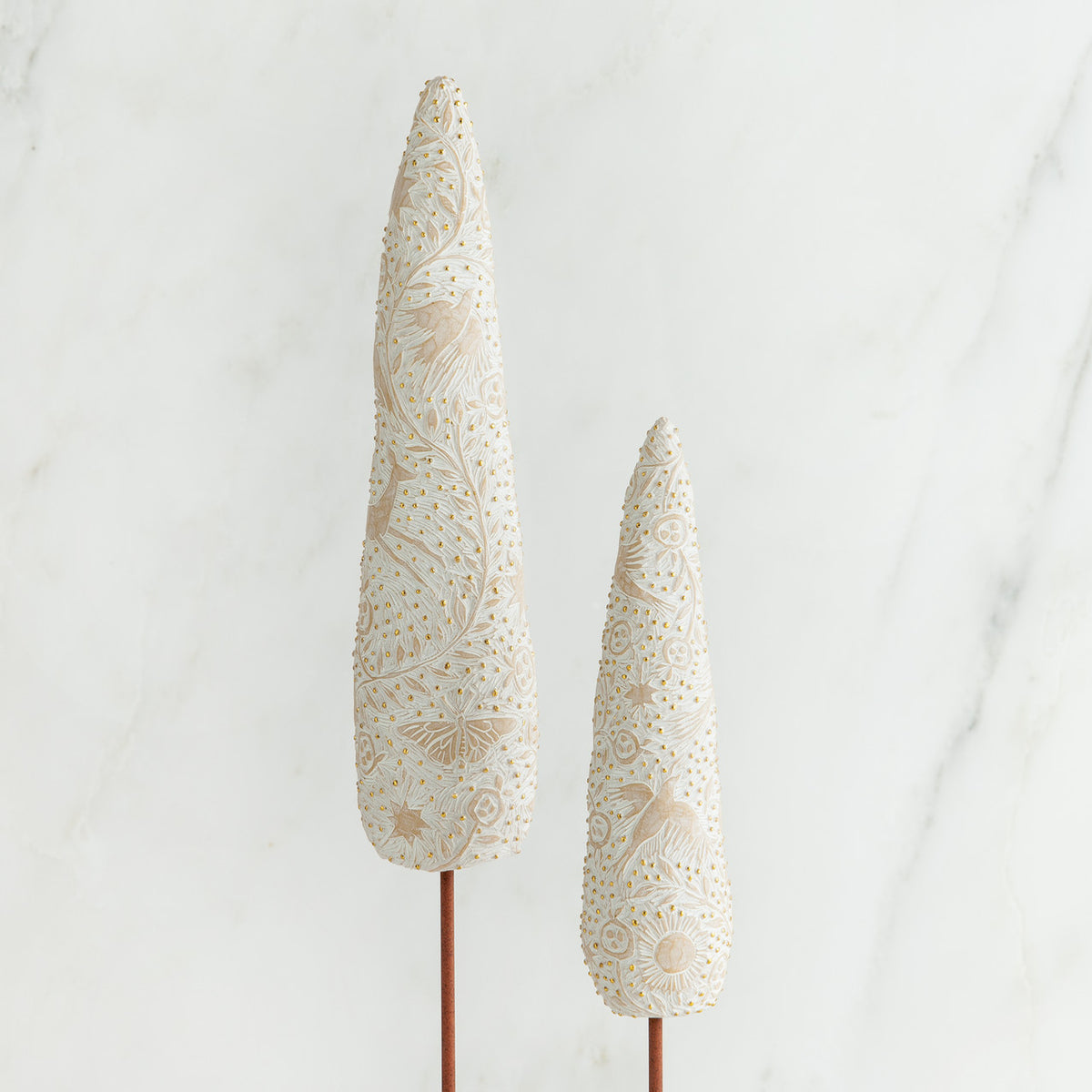 Set of two white tree figurines side by side