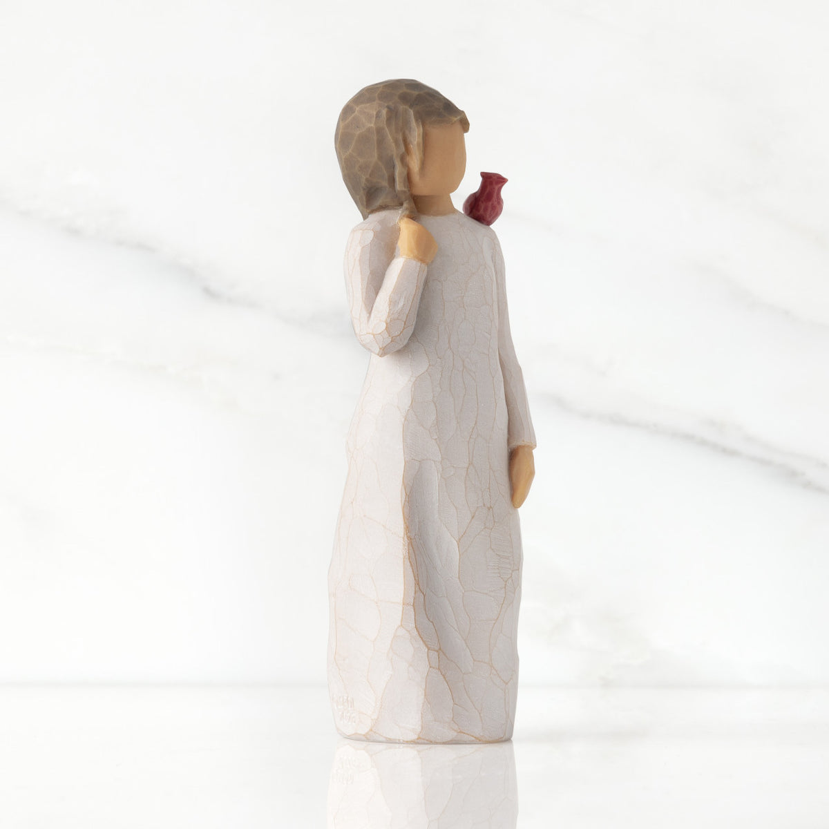 Right side of standing figure in cream dress with cardinal red bird perched on shoulder