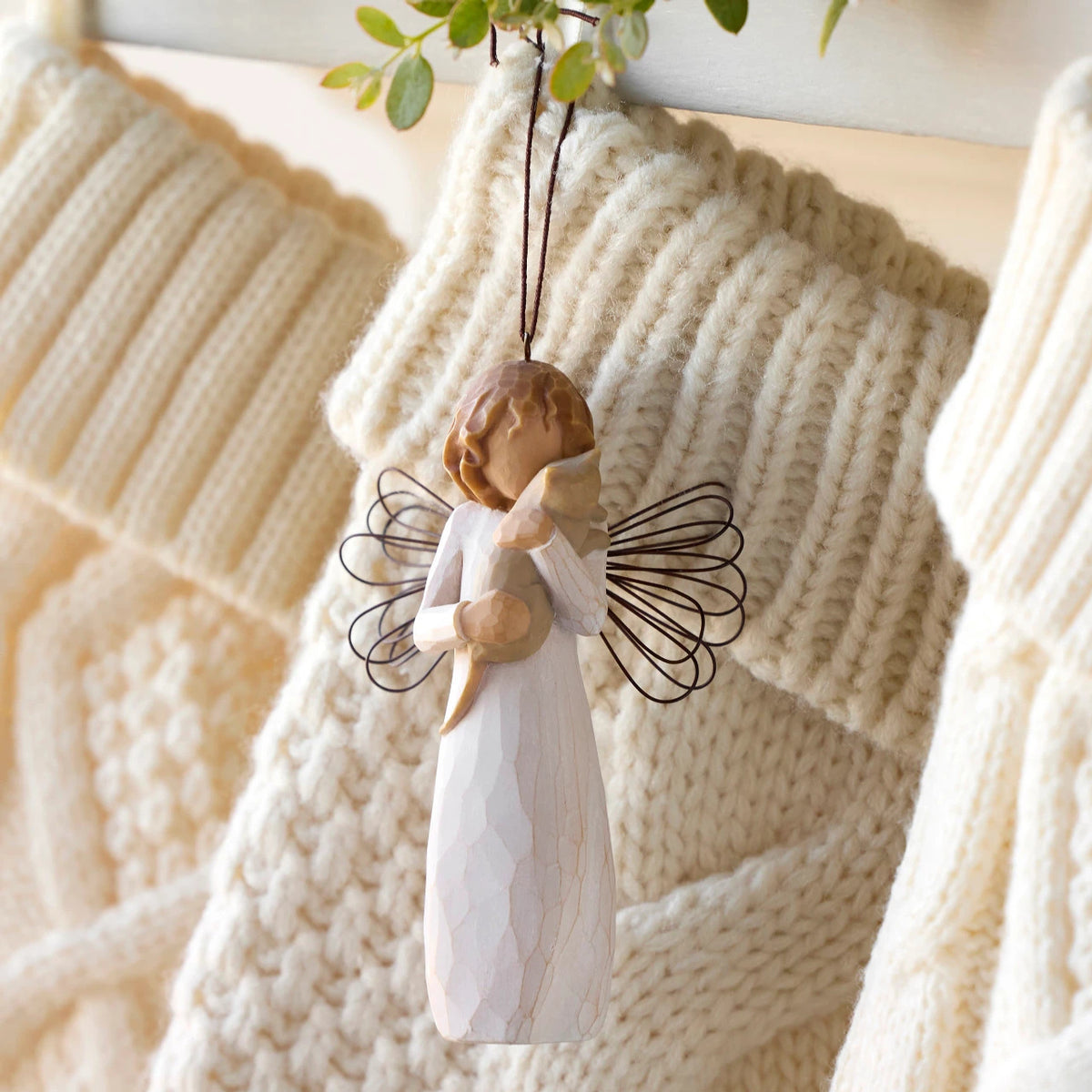 Willow Tree With affection Ornament, 4.5”h hand-painted resin figure in cream dress with wire wings, holding gray cat, brown elastic cord, hanging with cream knitted Christmas stockings