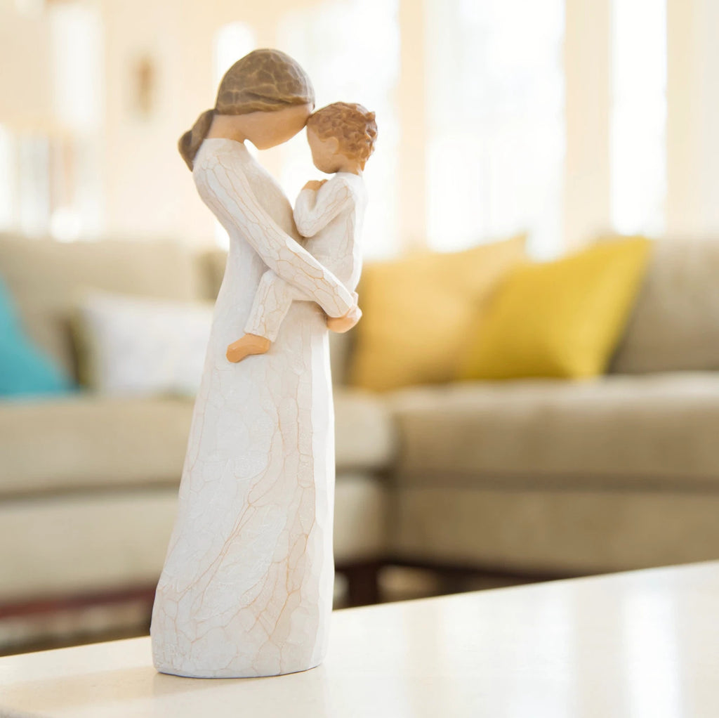 Willow Tree Tenderness, 8”h hand-painted standing resin figure holding toddler, foreheads touching, both dressed in cream, on shelf near a couch