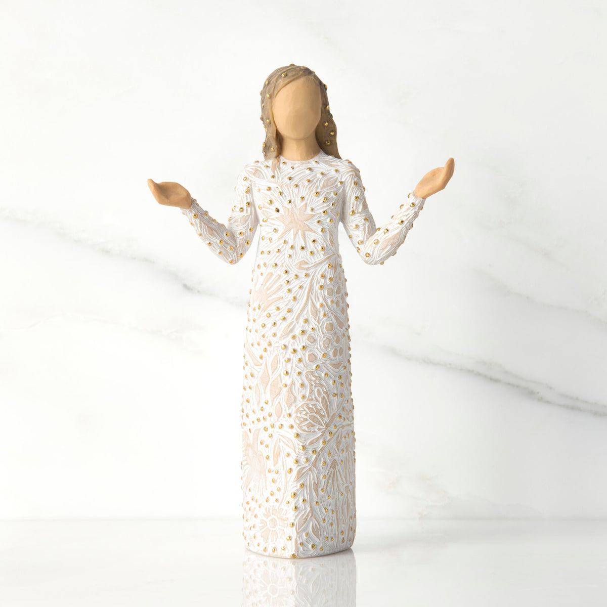 Front view of brunette girl figurine in white dress with gold dots holding her hands to the side